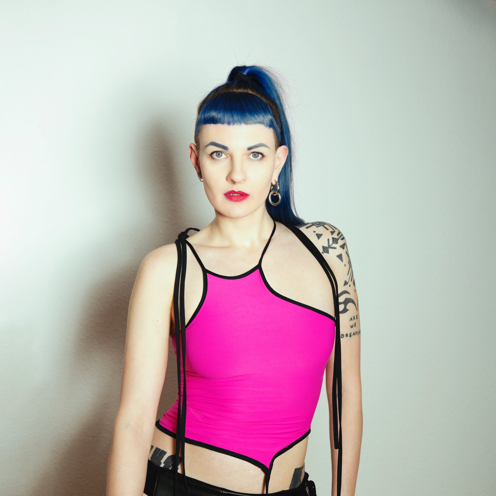 neon pink top with laces, woman with blue hair